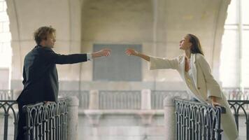 Lovers hold out their hands to each other at distance. Action. Beautiful couple in love on different sides of bridge reaches out to each other. Lovers stretch out their hands to each other over abyss video