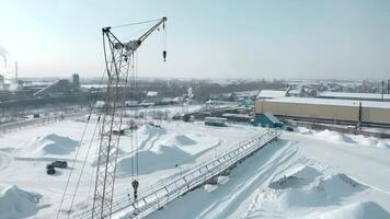 hiver yeux d'oiseau voir. agrafe. une grand grue permanent dans production des stands suivant à le ville et le route sur lequel le voitures conduire video