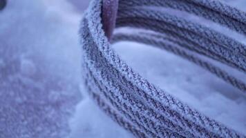 Close up of frozen metal cable covered by snow. Clip. Industrial background, concept of winter works at the construction site. video