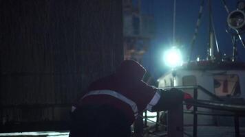marchande navire dans nuit port. agrafe. homme sur navire sur Contexte de Port lumières à nuit. arrivée à nuit commerce Port video