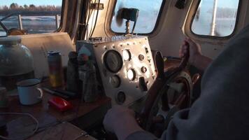 visie binnen van stuurhuis met ramen, kompas, stuurinrichting wiel, en dashboard. klem. een Mens matroos leidend haar oud en vuil schip. video