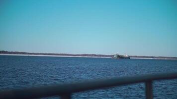 A snowy sea with ships.Clip. Huge ships with cargo move through the snowy sea, behind which the forest is visible. video