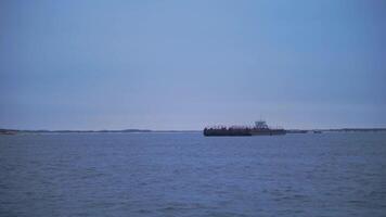 Barge floating on river on cloudy day. Clip. Beautiful river landscape with floating merchant ship. Barge crossing on river on cloudy day video