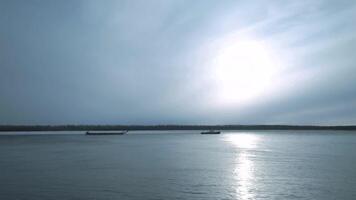 Barge floating on river on cloudy day. Clip. Beautiful river landscape with floating merchant ship. Barge crossing on river on cloudy day video