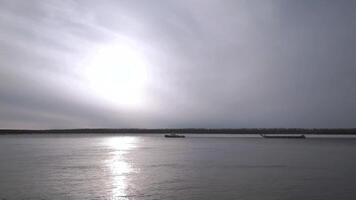 natural panorama com uma rio dentro cedo inverno e a frio luz solar refletido dentro água superfície grampo. floresta crescendo longe dentro a distância e calma água. video