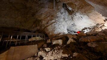turista cuevas en rocas acción. enorme rock cuevas con excursionismo caminos. dentro grande rocoso cueva en oscuro video