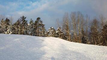 The sun has just risen in a cloudy sky over the snowy hill in Scandinavia video