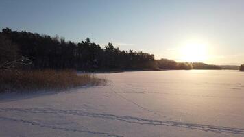 The sun has just risen and lights up a frozen lake in Scandinavia video