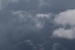 Cloudscape scenery, overcast weather above dark blue sky. Storm clouds floating in a rainy dull day with natural light. White and grey scenic environment background. Nature view. photo