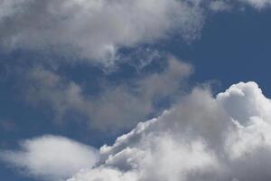 Cloudscape scenery, overcast weather above dark blue sky. Storm clouds floating in a rainy dull day with natural light. White and grey scenic environment background. Nature view. photo