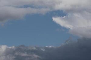 Cloudscape scenery, overcast weather above dark blue sky. Storm clouds floating in a rainy dull day with natural light. White and grey scenic environment background. Nature view. photo