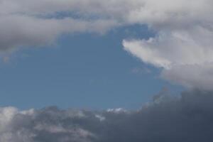 Cloudscape scenery, overcast weather above dark blue sky. Storm clouds floating in a rainy dull day with natural light. White and grey scenic environment background. Nature view. photo