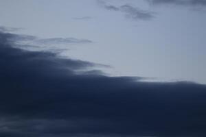 Cloudscape scenery, overcast weather above dark blue sky. Storm clouds floating in a rainy dull day with natural light. White and grey scenic environment background. Nature view. photo