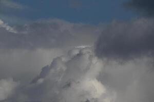 Cloudscape scenery, overcast weather above dark blue sky. Storm clouds floating in a rainy dull day with natural light. White and grey scenic environment background. Nature view. photo