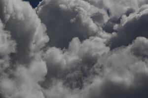 Cloudscape scenery, overcast weather above dark blue sky. Storm clouds floating in a rainy dull day with natural light. White and grey scenic environment background. Nature view. photo