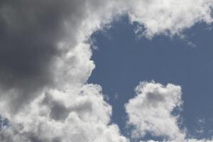 Cloudscape scenery, overcast weather above dark blue sky. Storm clouds floating in a rainy dull day with natural light. White and grey scenic environment background. Nature view. photo