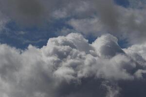 Cloudscape scenery, overcast weather above dark blue sky. Storm clouds floating in a rainy dull day with natural light. White and grey scenic environment background. Nature view. photo