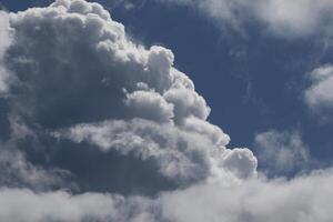Cloudscape scenery, overcast weather above dark blue sky. Storm clouds floating in a rainy dull day with natural light. White and grey scenic environment background. Nature view. photo