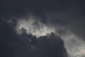 Cloudscape scenery, overcast weather above dark blue sky. Storm clouds floating in a rainy dull day with natural light. White and grey scenic environment background. Nature view. photo