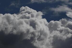 Cloudscape escenario, nublado clima encima oscuro azul cielo. tormenta nubes flotante en un lluvioso aburrido día con natural ligero. blanco y gris escénico ambiente antecedentes. naturaleza vista. foto