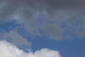 Cloudscape scenery, overcast weather above dark blue sky. Storm clouds floating in a rainy dull day with natural light. White and grey scenic environment background. Nature view. photo