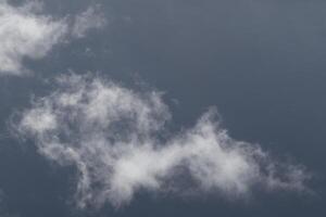 Cloudscape scenery, overcast weather above dark blue sky. Storm clouds floating in a rainy dull day with natural light. White and grey scenic environment background. Nature view. photo