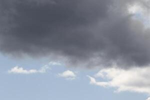 Cloudscape scenery, overcast weather above dark blue sky. Storm clouds floating in a rainy dull day with natural light. White and grey scenic environment background. Nature view. photo