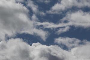 Cloudscape scenery, overcast weather above dark blue sky. Storm clouds floating in a rainy dull day with natural light. White and grey scenic environment background. Nature view. photo