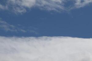 Cloudscape scenery, overcast weather above dark blue sky. Storm clouds floating in a rainy dull day with natural light. White and grey scenic environment background. Nature view. photo