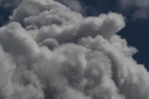 Cloudscape scenery, overcast weather above dark blue sky. Storm clouds floating in a rainy dull day with natural light. White and grey scenic environment background. Nature view. photo