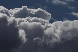 Cloudscape scenery, overcast weather above dark blue sky. Storm clouds floating in a rainy dull day with natural light. White and grey scenic environment background. Nature view. photo