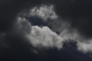 Cloudscape scenery, overcast weather above dark blue sky. Storm clouds floating in a rainy dull day with natural light. White and grey scenic environment background. Nature view. photo