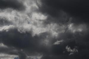 Cloudscape scenery, overcast weather above dark blue sky. Storm clouds floating in a rainy dull day with natural light. White and grey scenic environment background. Nature view. photo