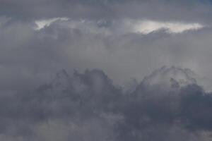 Cloudscape scenery, overcast weather above dark blue sky. Storm clouds floating in a rainy dull day with natural light. White and grey scenic environment background. Nature view. photo