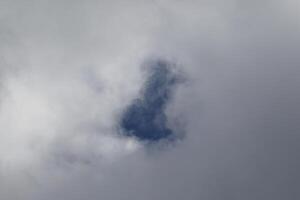 Cloudscape escenario, nublado clima encima oscuro azul cielo. tormenta nubes flotante en un lluvioso aburrido día con natural ligero. blanco y gris escénico ambiente antecedentes. naturaleza vista. foto