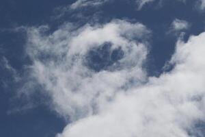 Cloudscape scenery, overcast weather above dark blue sky. Storm clouds floating in a rainy dull day with natural light. White and grey scenic environment background. Nature view. photo