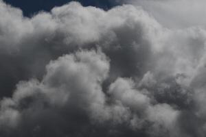 Cloudscape scenery, overcast weather above dark blue sky. Storm clouds floating in a rainy dull day with natural light. White and grey scenic environment background. Nature view. photo