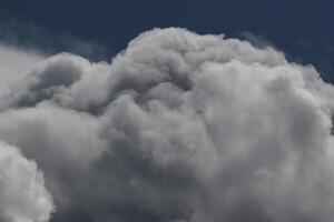 Cloudscape scenery, overcast weather above dark blue sky. Storm clouds floating in a rainy dull day with natural light. White and grey scenic environment background. Nature view. photo