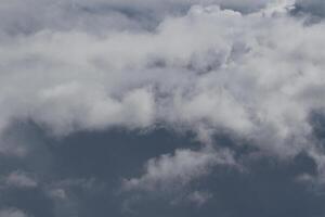 Cloudscape escenario, nublado clima encima oscuro azul cielo. tormenta nubes flotante en un lluvioso aburrido día con natural ligero. blanco y gris escénico ambiente antecedentes. naturaleza vista. foto