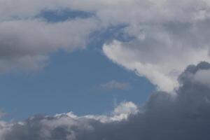 Cloudscape scenery, overcast weather above dark blue sky. Storm clouds floating in a rainy dull day with natural light. White and grey scenic environment background. Nature view. photo