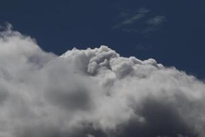 Cloudscape scenery, overcast weather above dark blue sky. Storm clouds floating in a rainy dull day with natural light. White and grey scenic environment background. Nature view. photo