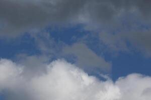 Cloudscape scenery, overcast weather above dark blue sky. Storm clouds floating in a rainy dull day with natural light. White and grey scenic environment background. Nature view. photo