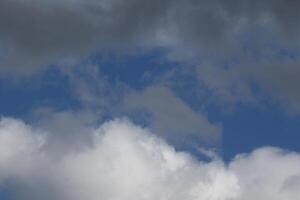 Cloudscape scenery, overcast weather above dark blue sky. Storm clouds floating in a rainy dull day with natural light. White and grey scenic environment background. Nature view. photo