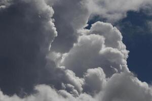 Cloudscape scenery, overcast weather above dark blue sky. Storm clouds floating in a rainy dull day with natural light. White and grey scenic environment background. Nature view. photo