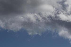 Cloudscape escenario, nublado clima encima oscuro azul cielo. tormenta nubes flotante en un lluvioso aburrido día con natural ligero. blanco y gris escénico ambiente antecedentes. naturaleza vista. foto