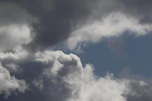 Cloudscape scenery, overcast weather above dark blue sky. Storm clouds floating in a rainy dull day with natural light. White and grey scenic environment background. Nature view. photo