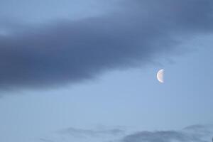 The colorful blue soft sky above the clouds with half moon photo