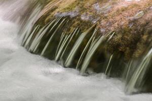 Mountain stream in the forest - long exposure and flowing water photo