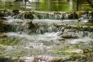 Mountain stream in the forest - long exposure and flowing water photo