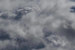 Cloudscape scenery, overcast weather above dark blue sky. Storm clouds floating in a rainy dull day with natural light. White and grey scenic environment background. Nature view. photo